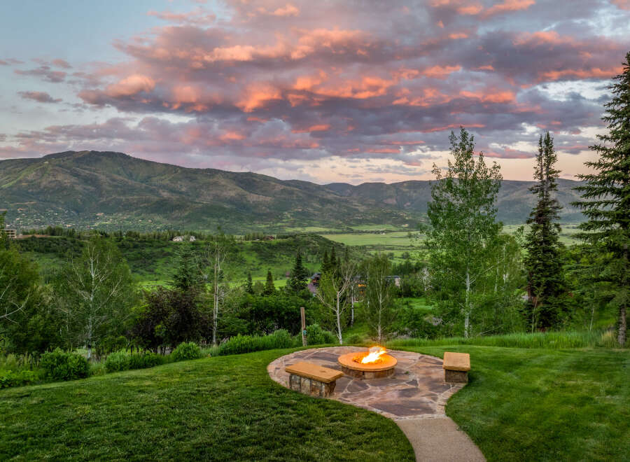 Experience breathtaking mountain views from this stunning property, featuring a cozy fire pit area perfect for evening relaxation.