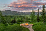 Experience breathtaking mountain views from this stunning property, featuring a cozy fire pit area perfect for evening relaxation.