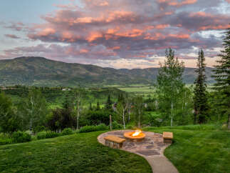 Experience breathtaking mountain views from this stunning property, featuring a cozy fire pit area perfect for evening relaxation.