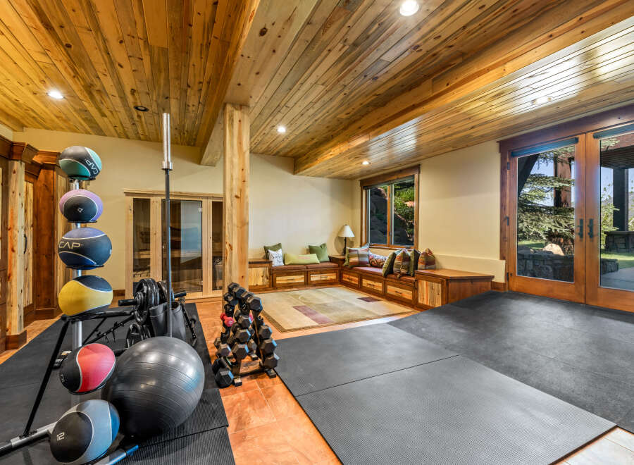 This home gym features a variety of equipment, including medicine balls, dumbbells, and a barbell, perfect for a full-body workout.