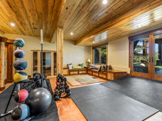 This home gym features a variety of equipment, including medicine balls, dumbbells, and a barbell, perfect for a full-body workout.
