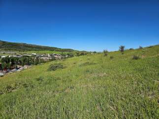 Discover breathtaking panoramic views from this elevated vantage point, overlooking a charming town nestled amidst rolling green hills.