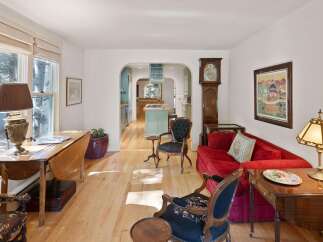 Step into this charming living space featuring a vibrant red sofa, perfect for cozy evenings.