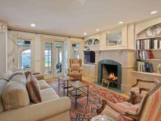 Step into this inviting living room, featuring a cozy fireplace with a marble surround and a beautifully detailed mantelpiece.