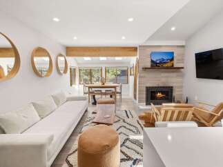 Experience modern mountain living in this beautifully appointed living space, featuring a cozy fireplace and a large sectional sofa perfect for gathering.