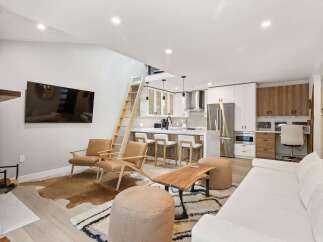 Experience modern living in this stunning open-concept space, featuring a sleek kitchen with stainless steel appliances and a breakfast bar perfect for entertaining.
