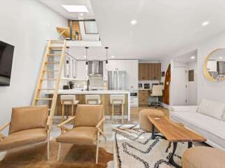 Experience modern living in this stylish loft featuring a sleek kitchen with stainless steel appliances and a breakfast bar.