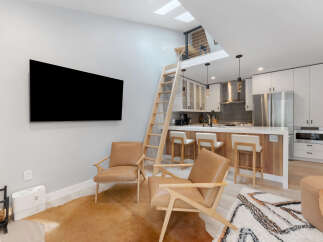 Experience modern living in this stylish loft apartment, featuring a sleek kitchen with stainless steel appliances and a breakfast bar perfect for casual dining.