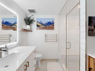 Experience modern luxury in this stunning bathroom, featuring a sleek vanity with an integrated sink and a bright LED-lit mirror.
