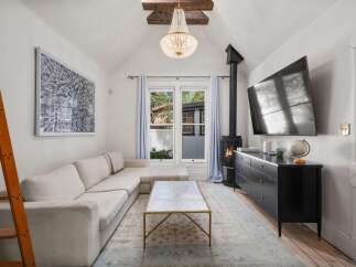 Cozy living room featuring a plush sectional sofa, a modern gas fireplace, and a large flat-screen TV.