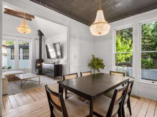Experience elegant dining in this charming space, featuring a dark wood table with cane-backed chairs perfect for intimate gatherings.