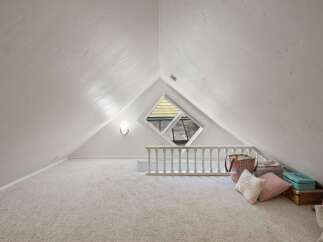 Discover this charming attic space, perfect for a cozy reading nook or a creative studio.