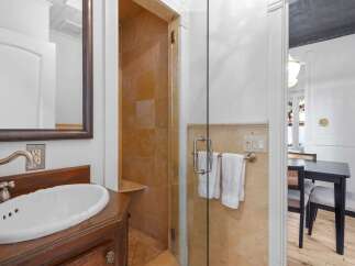 This bathroom features a beautiful vessel sink atop a dark wood vanity, complemented by a brushed nickel faucet.