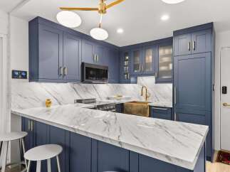 Experience modern luxury in this stunning kitchen, featuring sleek navy blue cabinetry with elegant gold hardware.