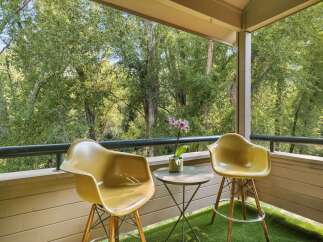 Enjoy your morning coffee or evening drink on this charming balcony, surrounded by lush greenery.