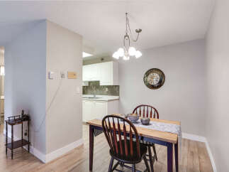 This dining area features a wooden table with two chairs, set against a neutral gray wall.