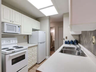 Discover this charming kitchen featuring crisp white cabinetry and a convenient built-in microwave.