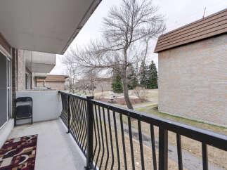 Enjoy your morning coffee on this private balcony, offering a serene view of the surrounding parkland and mature trees.
