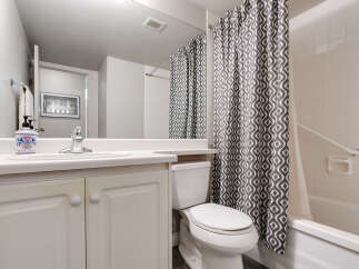 This bathroom features a clean and functional design with a white vanity and a matching toilet.