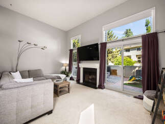 Experience modern living in this spacious living room featuring a cozy fireplace and a large TV mounted above.