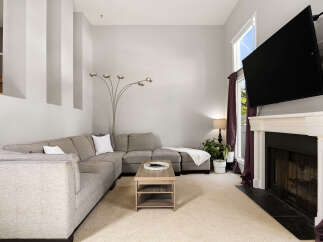 Experience modern living in this spacious living room, featuring a large sectional sofa perfect for gatherings and a sleek coffee table.