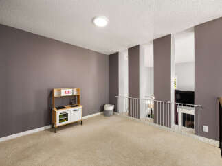 This spacious loft area features a neutral carpet and a modern ceiling light, creating a bright and airy atmosphere.