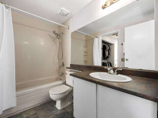 This bathroom features a bathtub with a shower and a white shower curtain.