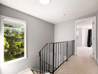 This image showcases a bright and airy upstairs hallway with a large window offering views of lush greenery.