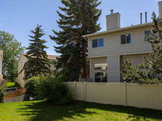 Enjoy the outdoors in this charming property featuring a private backyard with a beige vinyl fence, perfect for relaxation and entertaining.