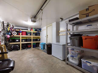Maximize your storage with this spacious garage, featuring ample shelving units and overhead storage solutions.