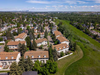 Discover this charming townhouse complex nestled beside a lush green space, offering a serene retreat.