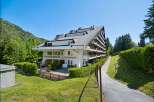Discover this stunning multi-story apartment building nestled amidst lush greenery and rolling hills.