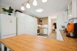 Discover this modern kitchen featuring ample white cabinetry and a sleek Bosch refrigerator.