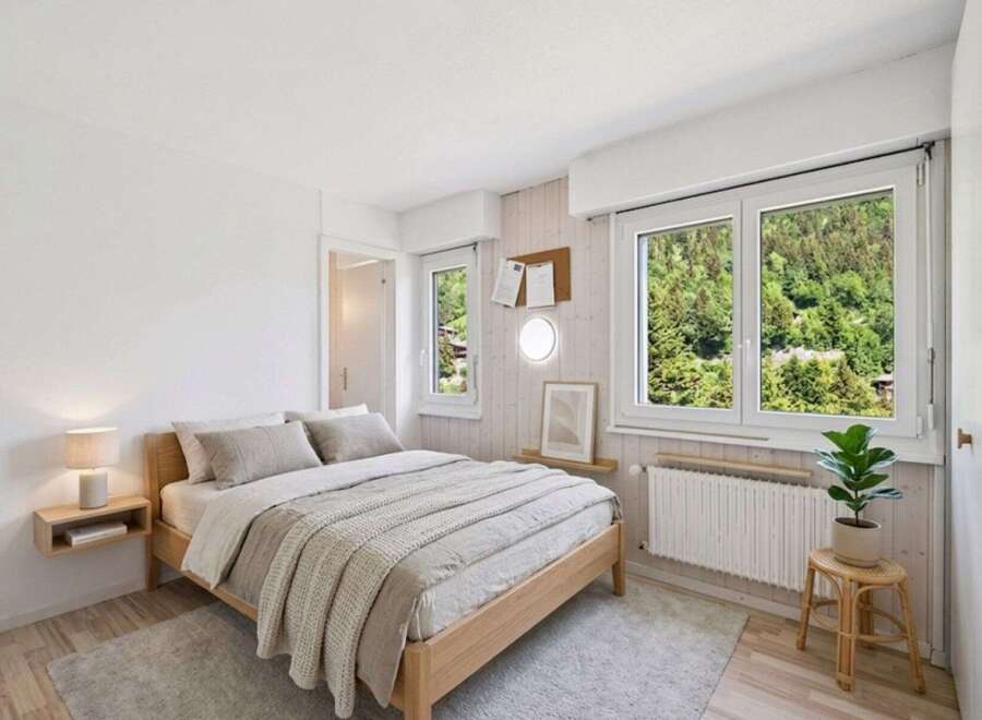 Experience serene living in this charming bedroom, featuring a comfortable bed adorned with plush linens and a cozy knit throw.