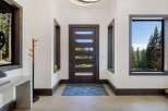Step into this inviting entryway featuring a modern dark wood door with horizontal glass panels, allowing natural light to flood the space.