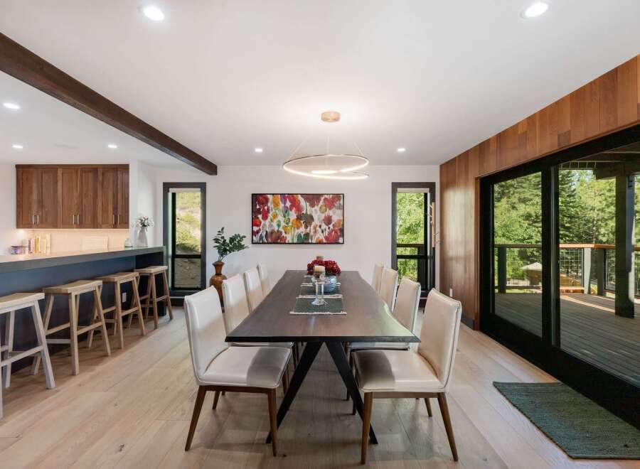 Experience modern living in this stunning dining area, featuring a sleek dark wood table surrounded by elegant cream upholstered chairs.