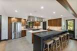 Experience luxury and functionality in this stunning modern kitchen, featuring rich walnut cabinetry and a sleek stainless steel range hood.