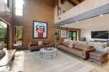 Experience luxury living in this stunning modern home featuring a soaring wood-paneled living room with a dramatic vaulted ceiling and abundant natural light.