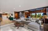Experience breathtaking mountain and lake views from this stunning living room, featuring a large sectional sofa perfect for relaxation.