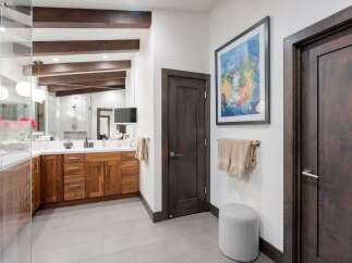 Experience luxury in this modern bathroom featuring a spacious double vanity with rich walnut cabinetry and a sleek white countertop.