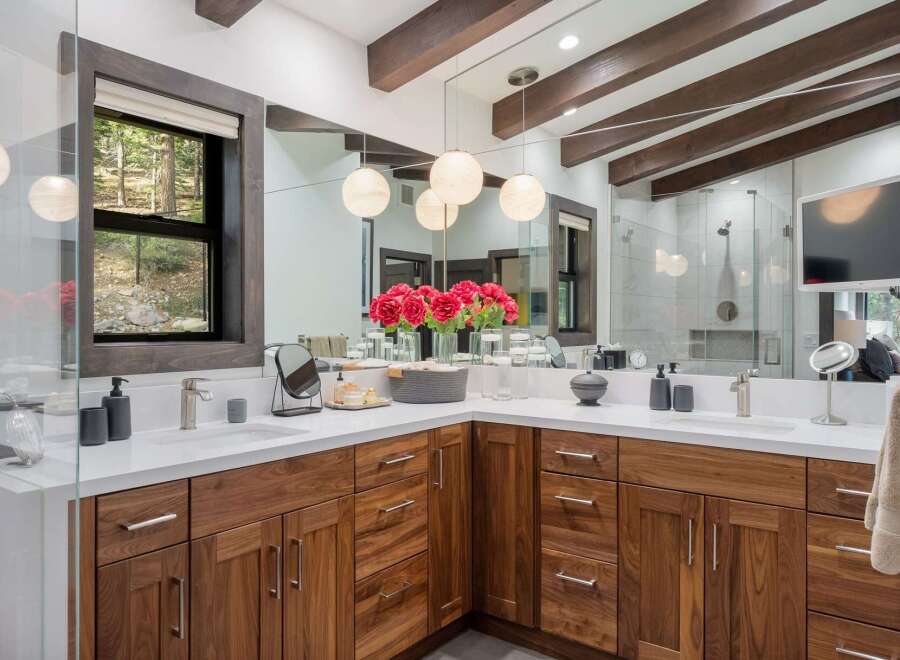 Experience luxury in this stunning bathroom featuring a spacious double vanity with rich walnut cabinetry and sleek quartz countertops.