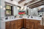 Experience luxury in this stunning bathroom featuring a spacious double vanity with rich walnut cabinetry and sleek quartz countertops.