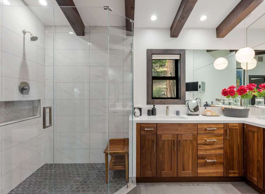 Experience luxury in this stunning bathroom featuring a spacious walk-in shower with marble tile and a modern showerhead.