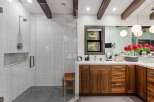Experience luxury in this stunning bathroom featuring a spacious walk-in shower with marble tile and a modern showerhead.