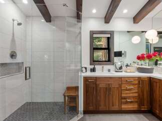 Experience luxury in this stunning bathroom featuring a spacious walk-in shower with marble tile and a modern showerhead.