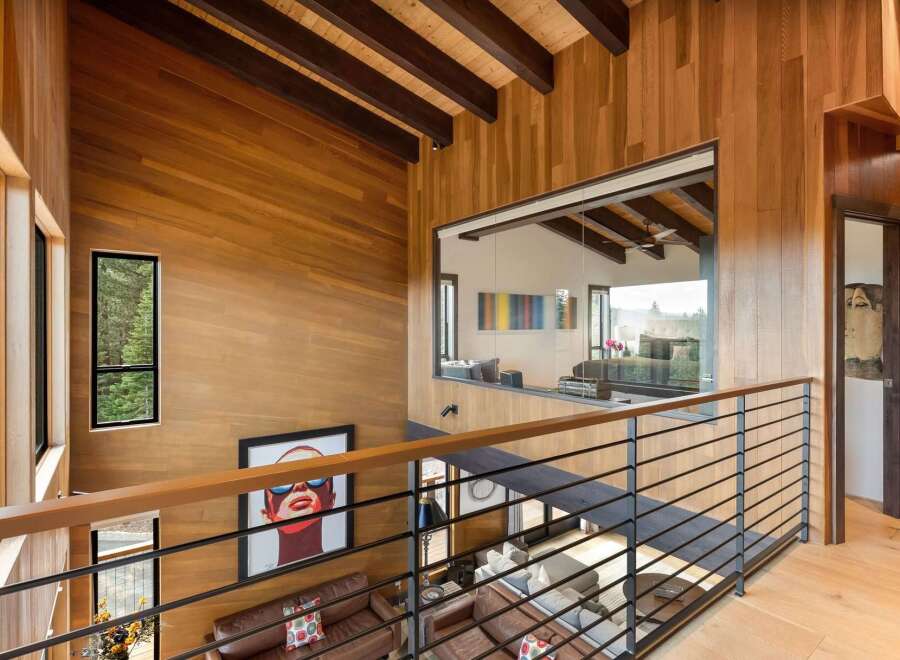 Experience modern luxury in this stunning home featuring warm wood paneling and exposed beams throughout.