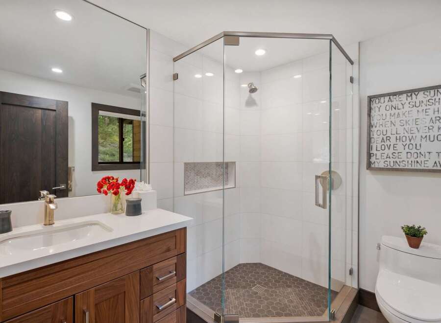 Experience modern luxury in this stunning bathroom featuring a spacious glass-enclosed shower with sleek tilework and a hexagonal floor.