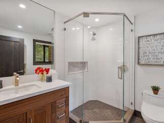 Experience modern luxury in this stunning bathroom featuring a spacious glass-enclosed shower with sleek tilework and a hexagonal floor.