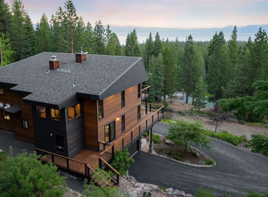 Experience luxury mountain living in this stunning modern home, nestled amidst towering pine trees with breathtaking lake and mountain views.