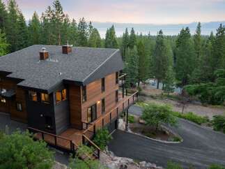 Experience luxury mountain living in this stunning modern home, nestled amidst towering pine trees with breathtaking lake and mountain views.